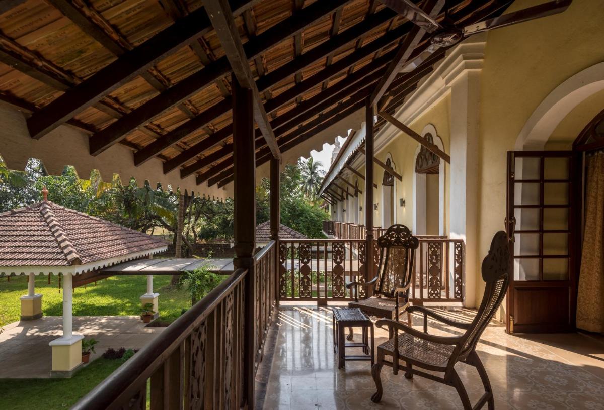 a porch of a house with a rocking chair at The Postcard Cuelim, Goa in Cansaulim