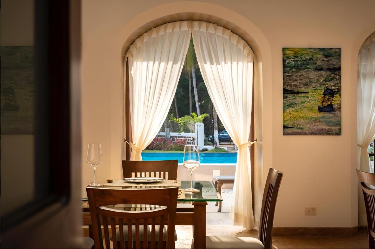 a dining room with a table and a window at The Postcard Cuelim, Goa in Cansaulim