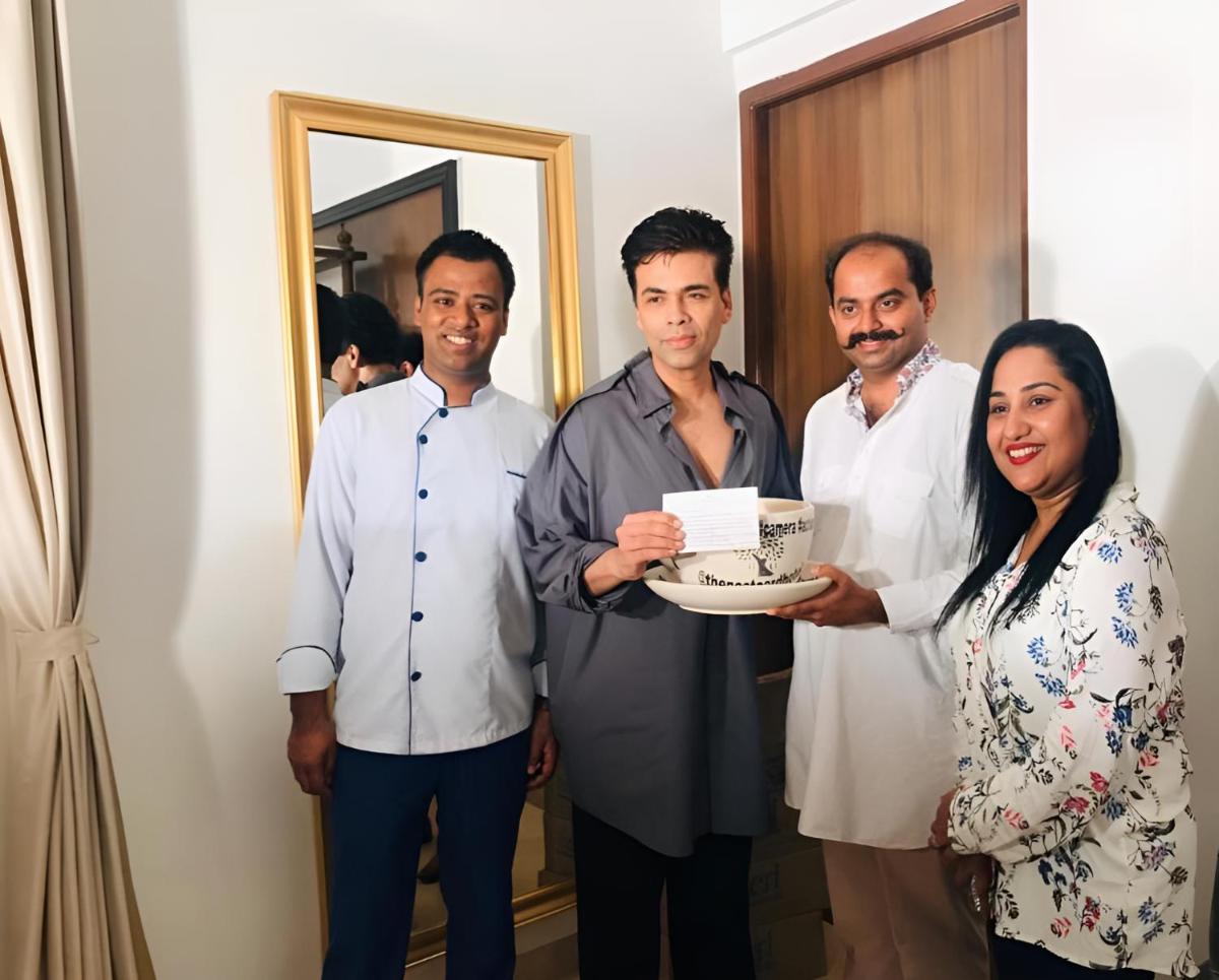 a group of men and a woman holding a cake at The Postcard Cuelim, Goa in Cansaulim
