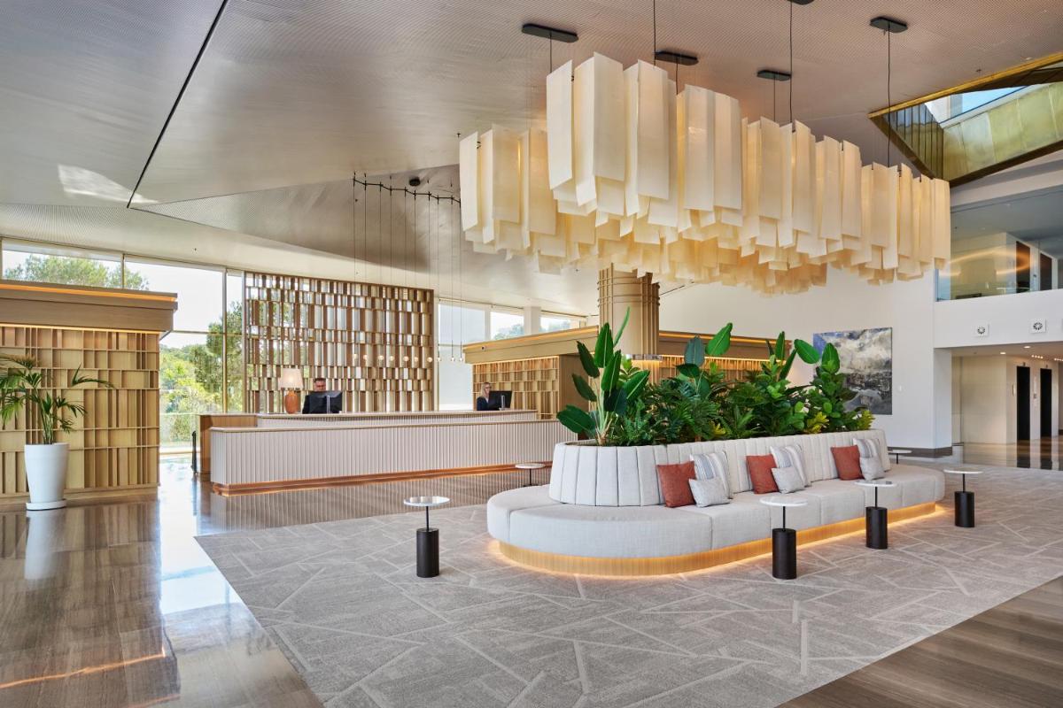 Un vestíbulo con un sofá blanco y plantas. en Hipotels Playa de Palma Palace&Spa, en Playa de Palma