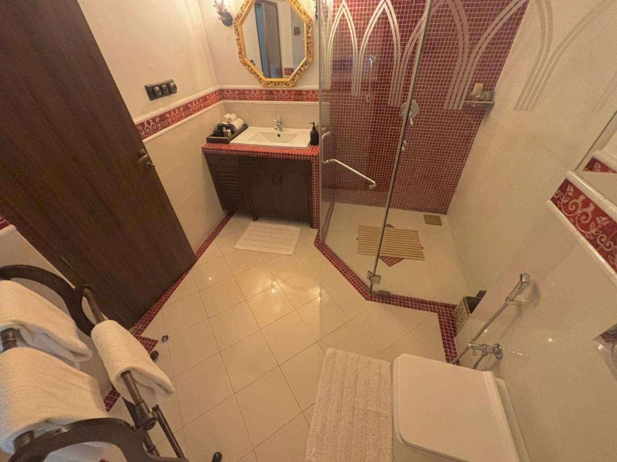 a bathroom with a shower and a sink and a toilet at The Postcard Cuelim, Goa in Cansaulim