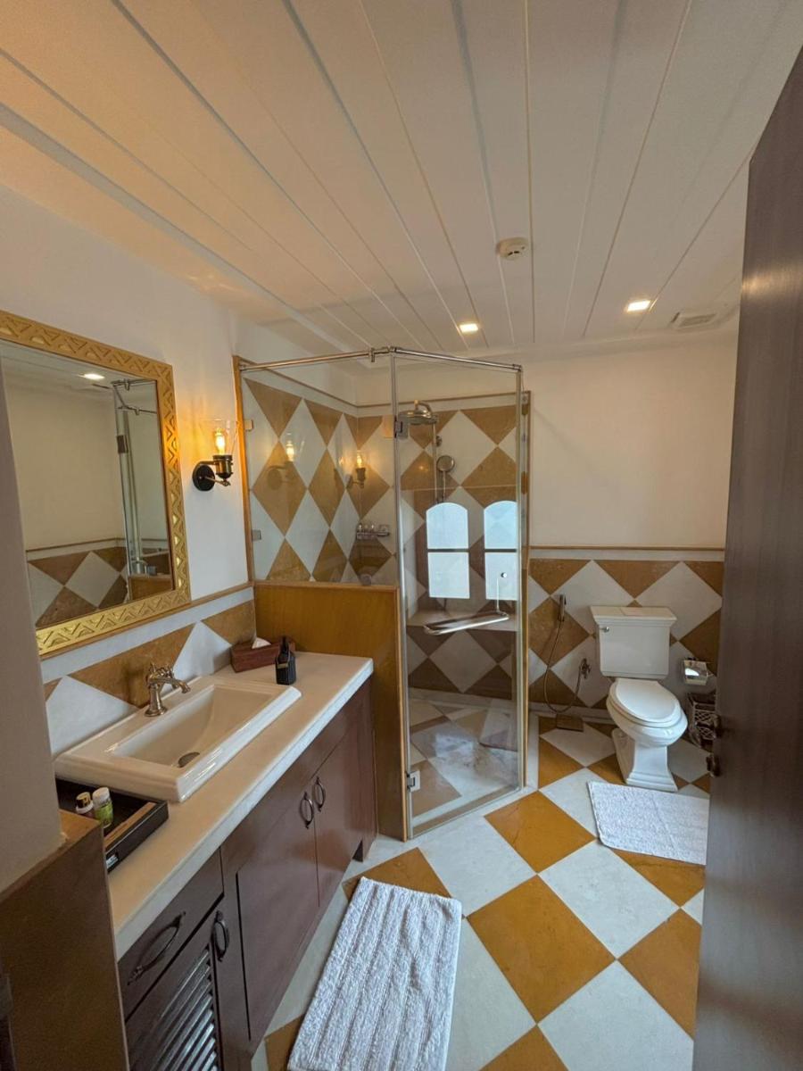 a bathroom with a sink and a toilet and a mirror at The Postcard Cuelim, Goa in Cansaulim