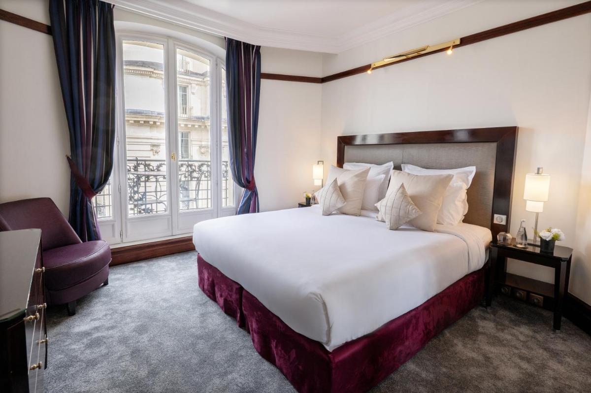 une chambre avec un grand lit blanc et une fenêtre dans l'établissement Hôtel Pont Royal Paris, à Paris