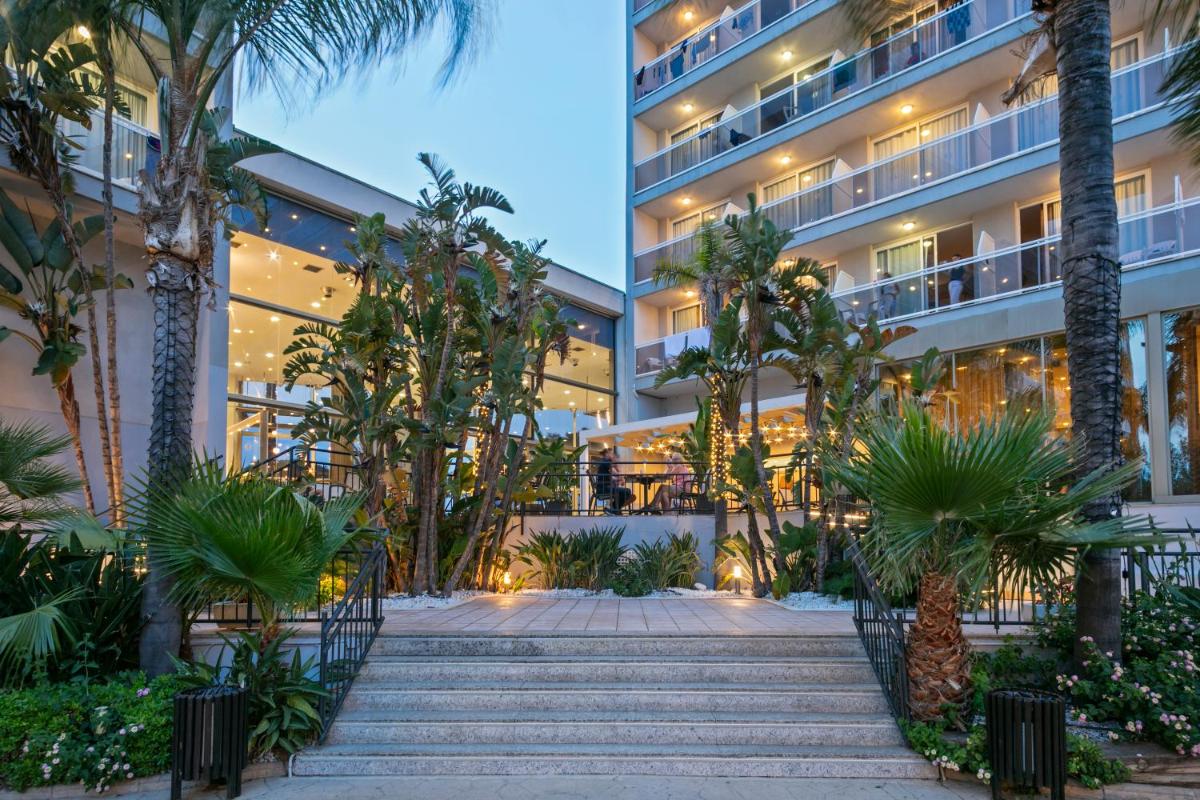 un hotel con palmeras frente a un edificio en Sol Costa Daurada, en Salou