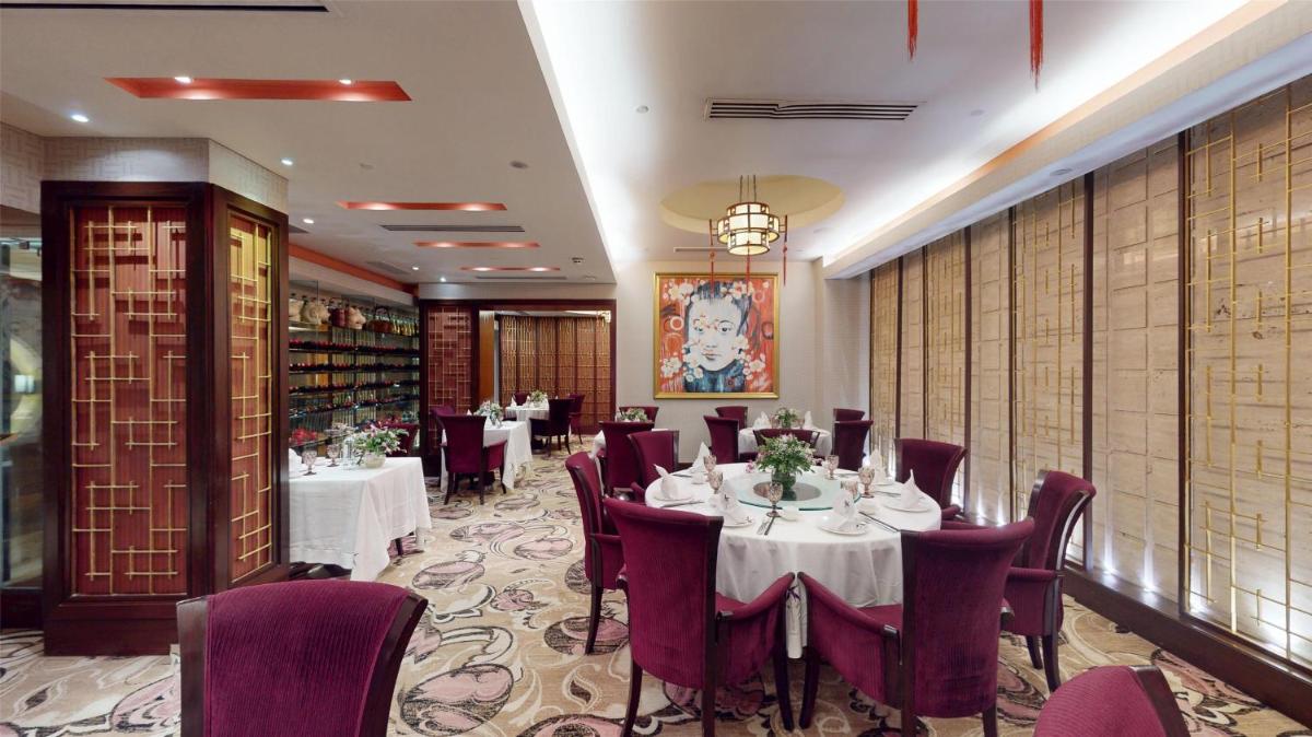 a dining room with tables and purple chairs at Radisson Blu Hotel, Nagpur in Nagpur