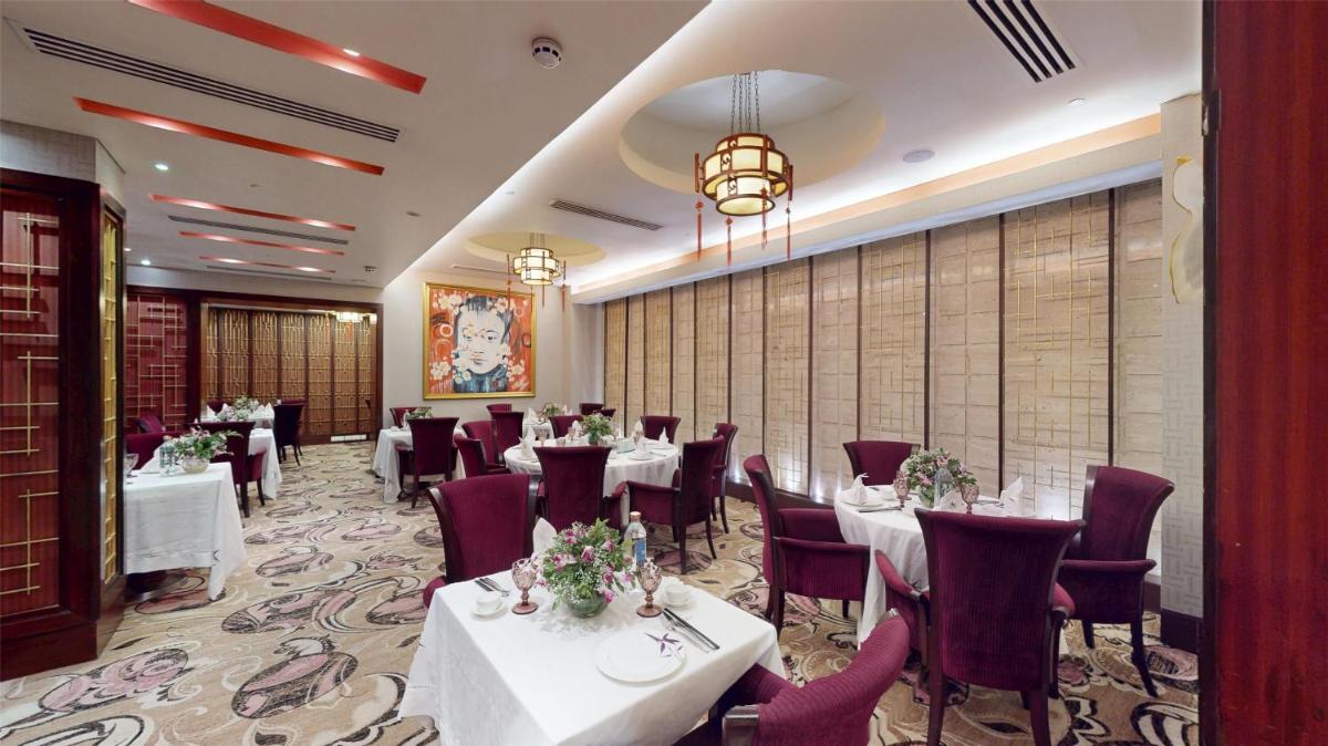 a dining room with white tables and red chairs at Radisson Blu Hotel, Nagpur in Nagpur