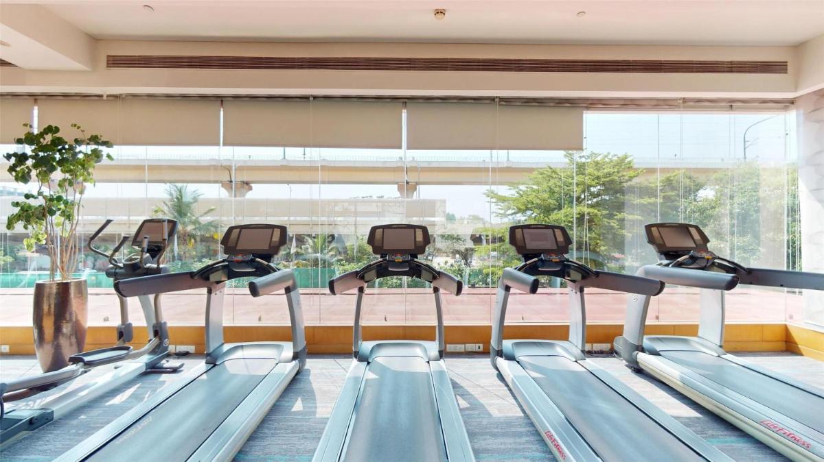 a row of treadmills in a gym with a large window at Radisson Blu Hotel, Nagpur in Nagpur