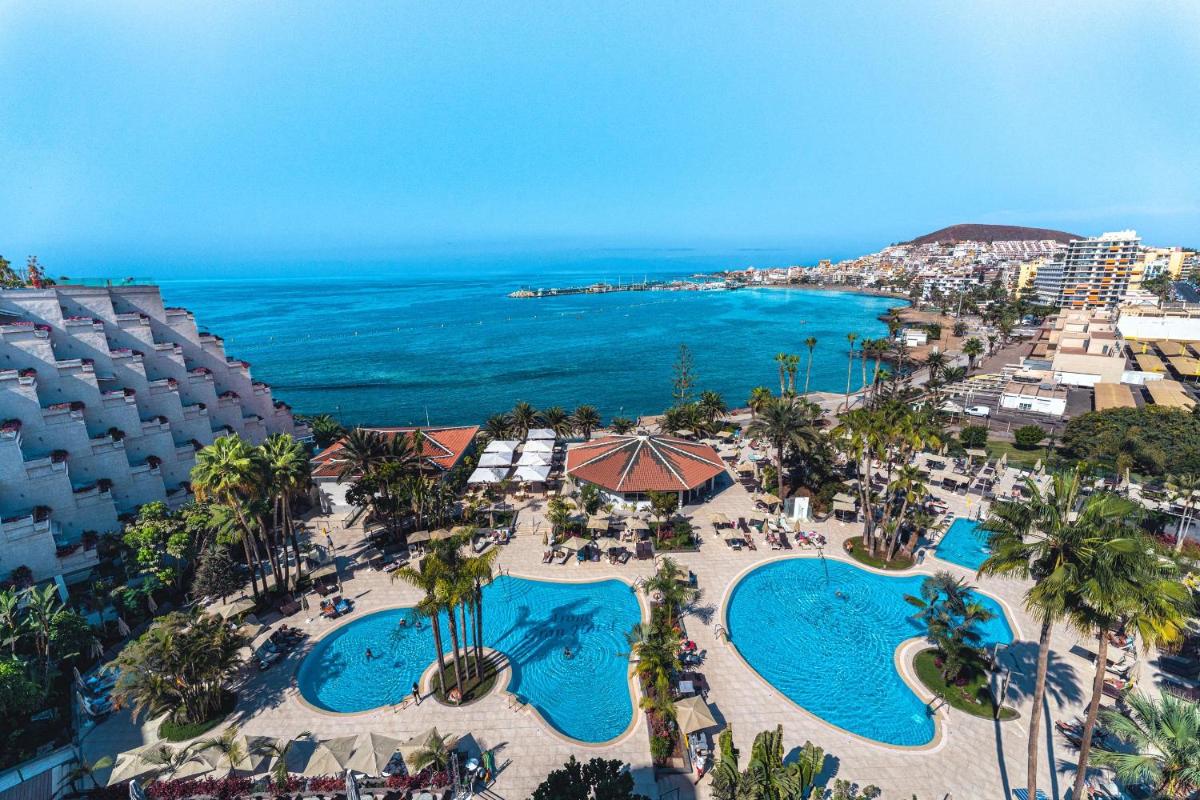 Una vista aérea de un resort con dos piscinas y el océano. en Spring Arona Gran Hotel - Adults Only, en Los Cristianos