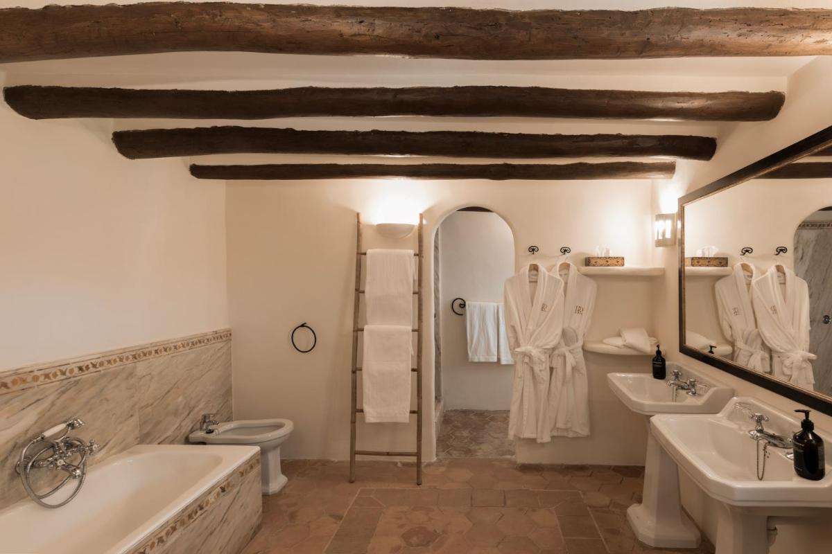 Un baño con dos lavabos, una bañera y un inodoro. en Reserva Rotana Golf Resort, en Manacor