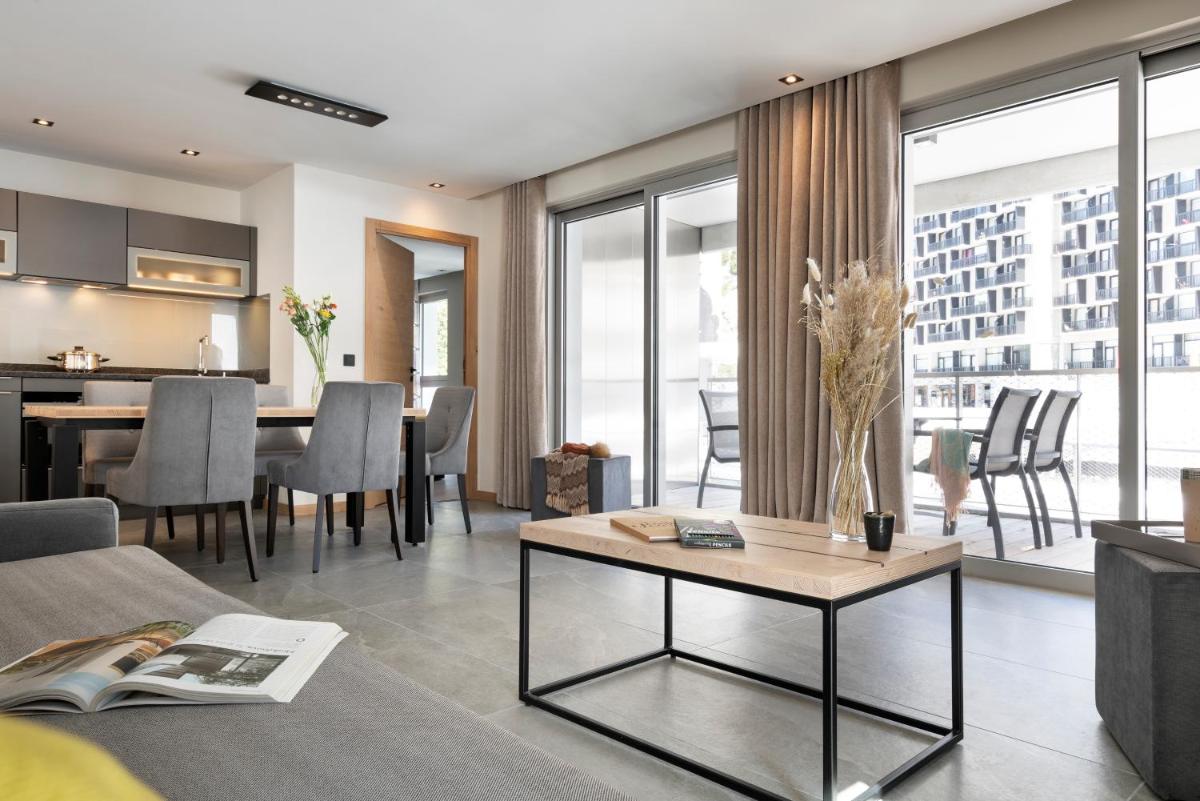 un salon avec un canapé et une table dans l'établissement MGM Hôtels & Résidences - Résidence Alhéna, à Flaine