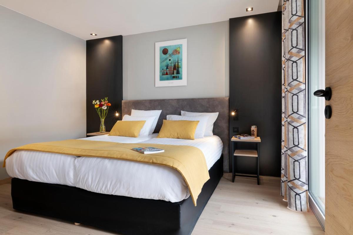 une chambre avec un grand lit avec des oreillers jaunes dans l'établissement MGM Hôtels & Résidences - Résidence Alhéna, à Flaine