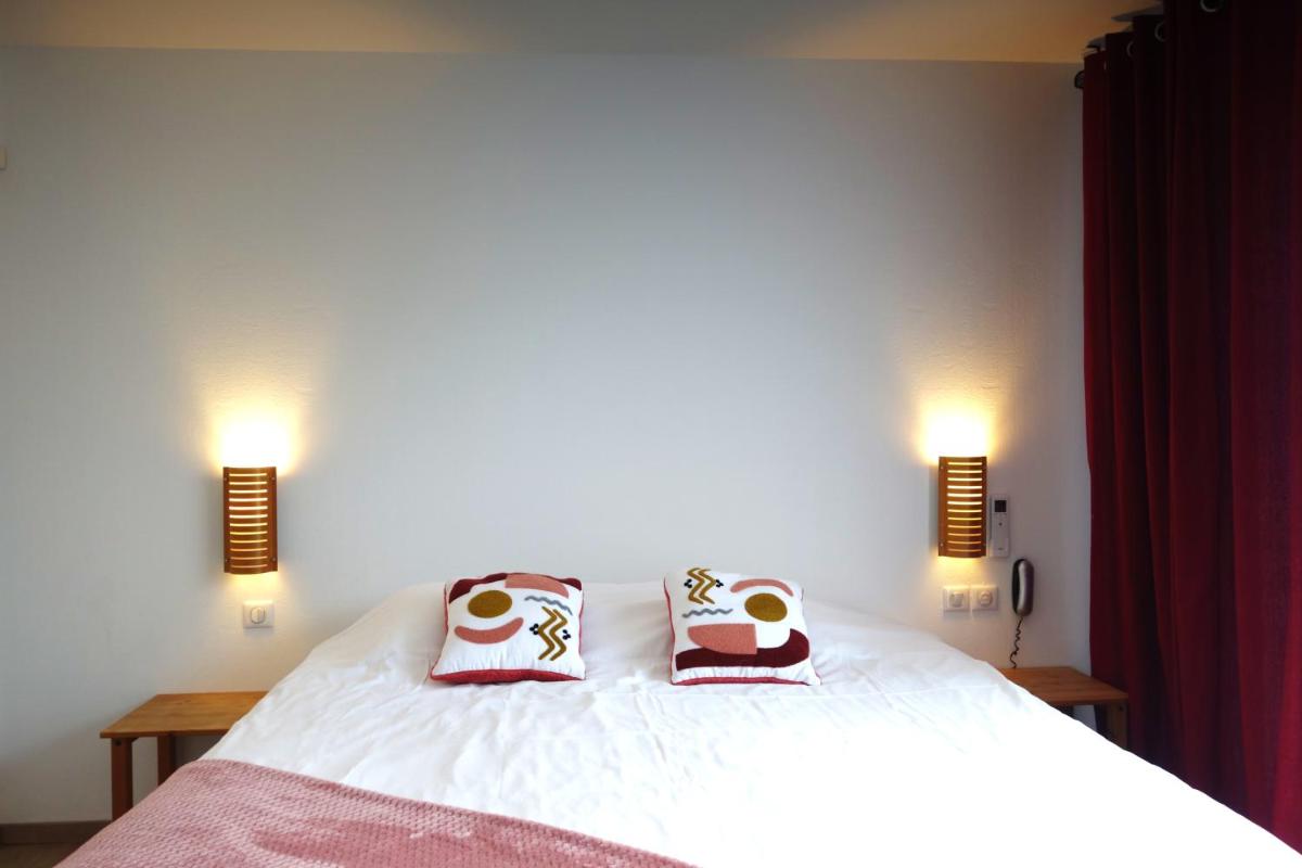 Un ou plusieurs lits dans un hébergement de l'établissement Hôtel La Ségalière Spa Bar