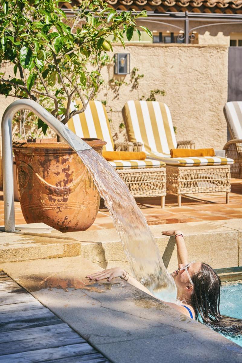 une jeune fille joue dans une fontaine dans l'établissement La Ferme D'Augustin, à Saint-Tropez