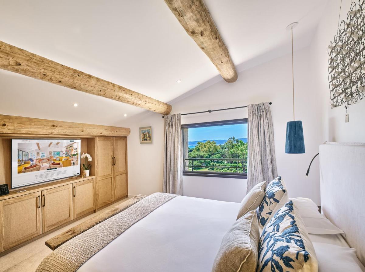 une chambre avec un lit et une grande fenêtre dans l'établissement La Ferme D'Augustin, à Saint-Tropez 235 autres photos