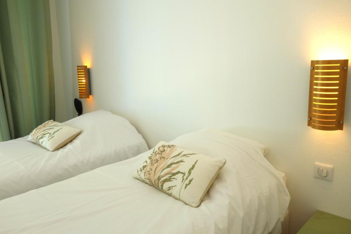 Un ou plusieurs lits dans un hébergement de l'établissement Hôtel La Ségalière Spa Bar