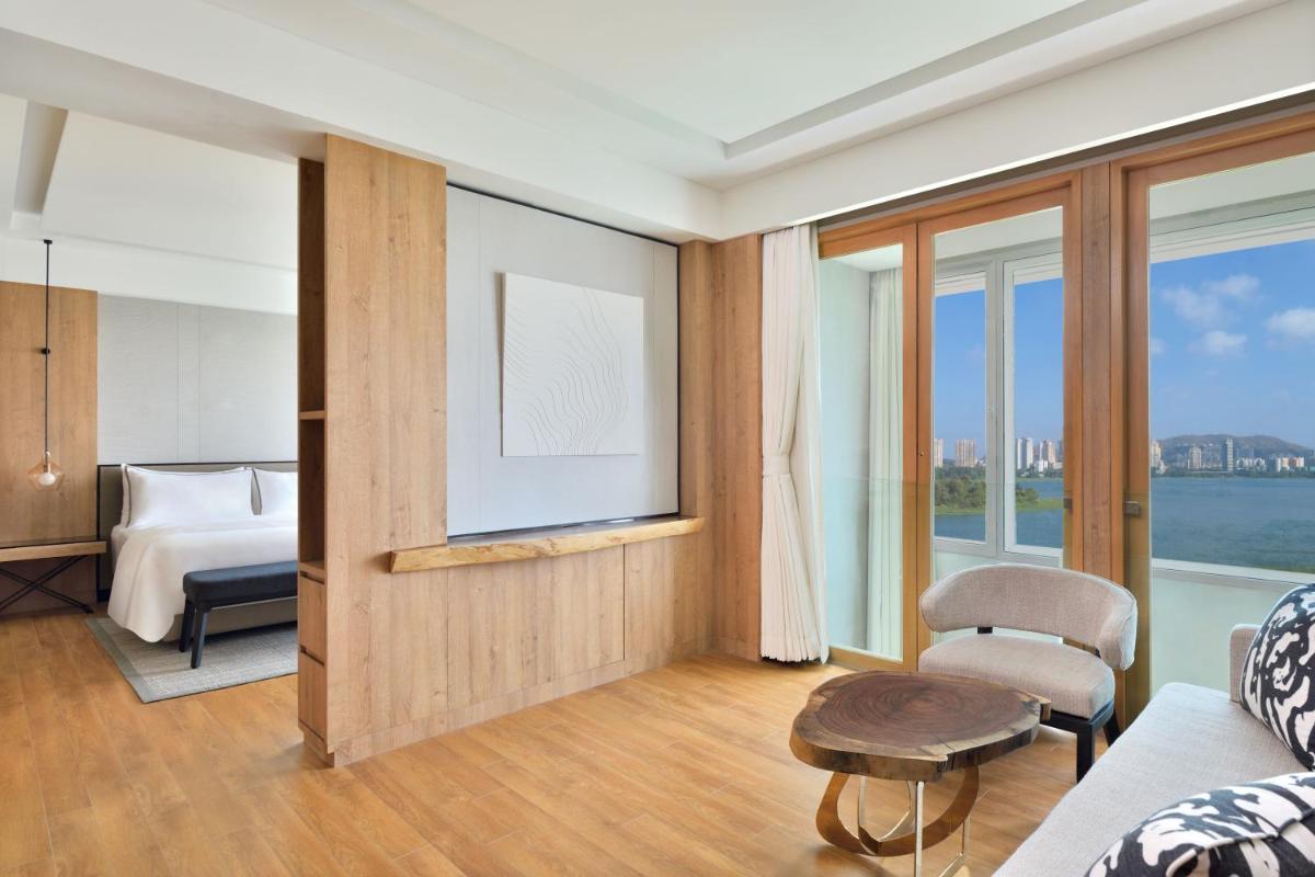 a living room with a bed and a television at The Westin Mumbai Powai Lake in Mumbai