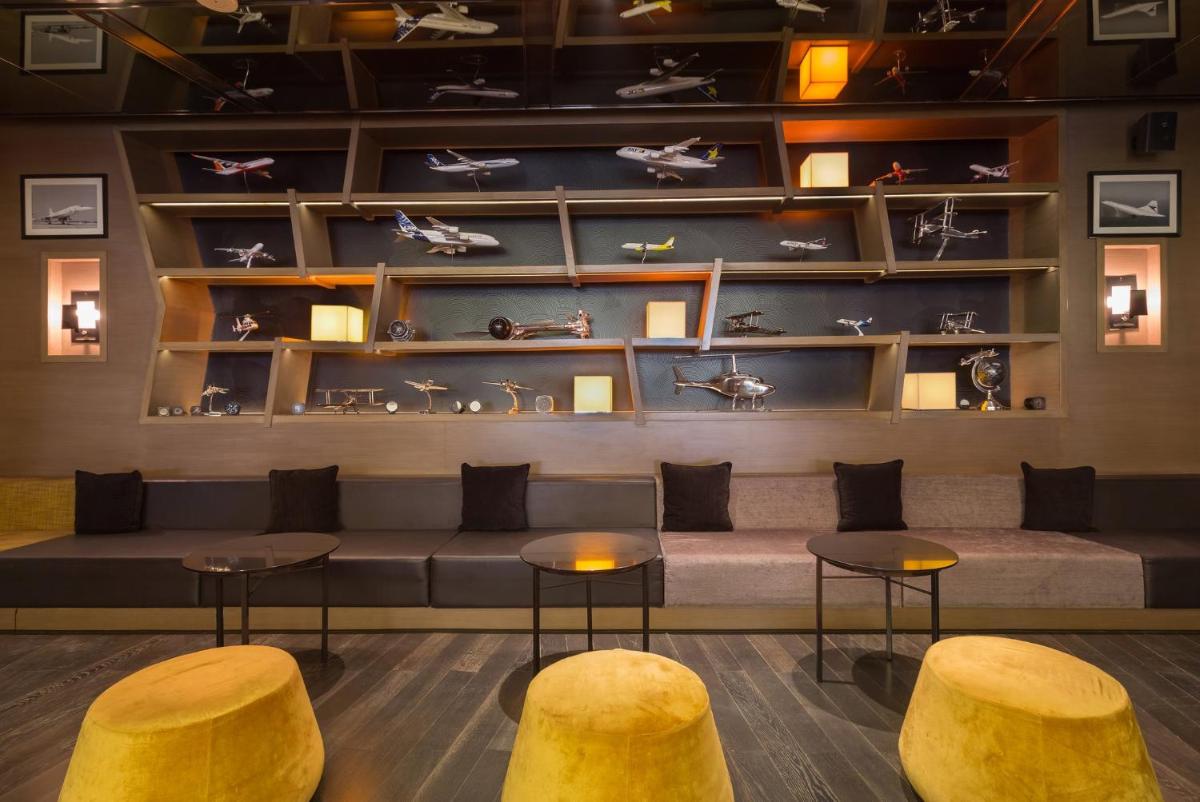 a lobby with a couch and two stools and tables at Holiday Inn New Delhi Aerocity by IHG in New Delhi