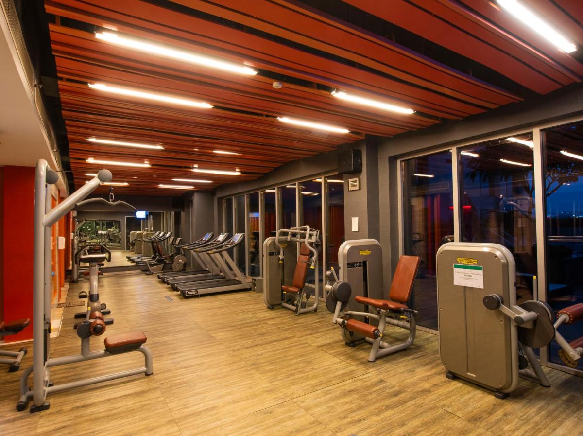 a gym with a row of treadmills and machines at Holiday Inn New Delhi Aerocity by IHG in New Delhi