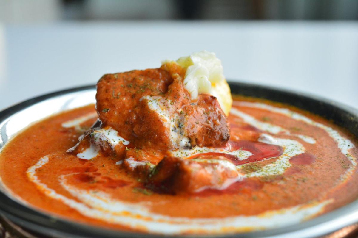 a bowl of tomato soup with a piece of food at Holiday Inn New Delhi Aerocity by IHG in New Delhi
