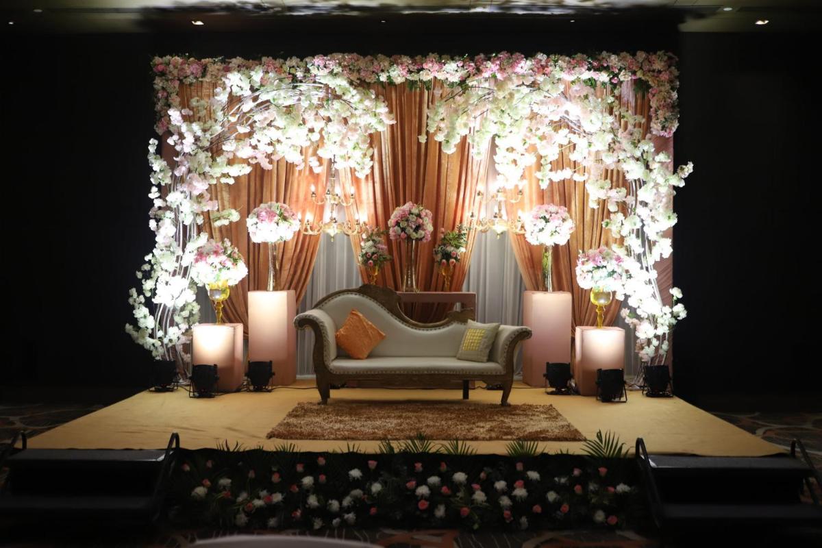 a couch on a stage with flowers and candles at Holiday Inn New Delhi Aerocity by IHG in New Delhi