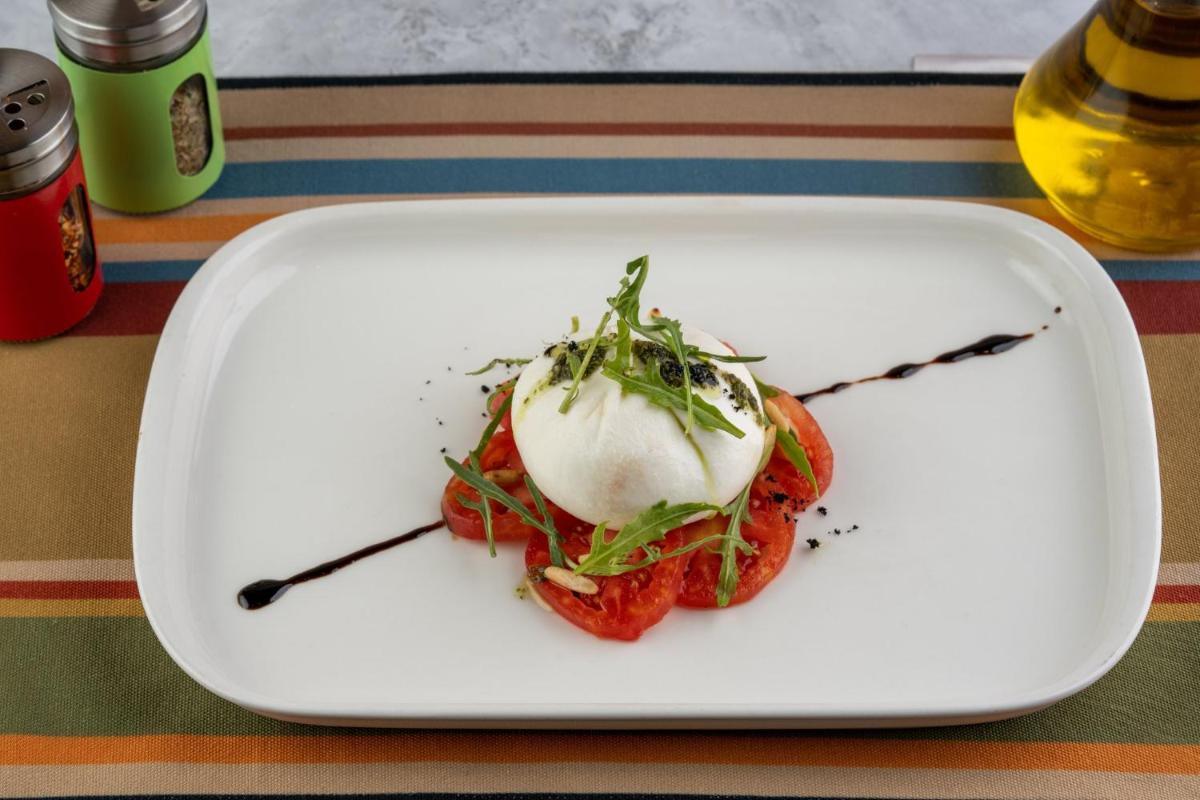 a white plate with food on a table at Holiday Inn New Delhi Aerocity by IHG in New Delhi