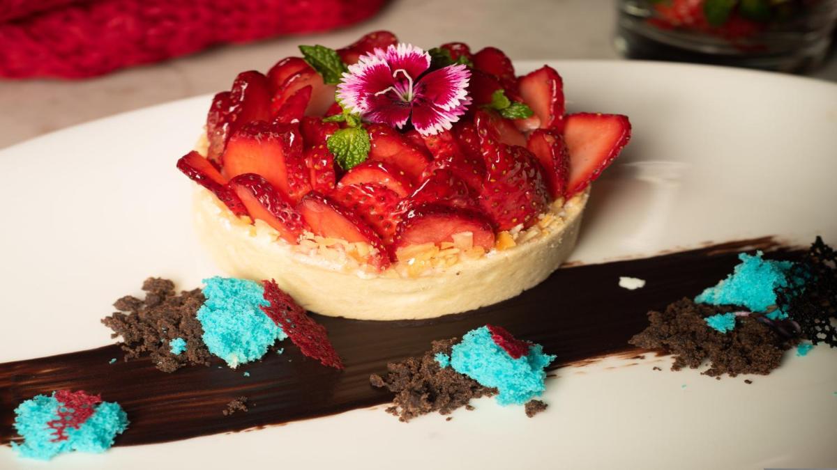 a dessert with strawberries on a white plate at Holiday Inn New Delhi Aerocity by IHG in New Delhi