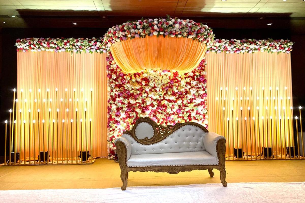 a couch in front of a stage with flowers at Holiday Inn New Delhi Aerocity by IHG in New Delhi
