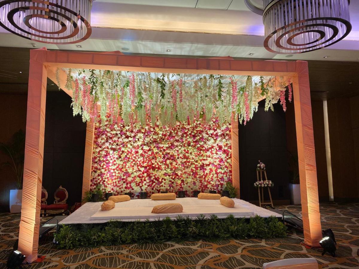 a bed in a room with a wall of flowers at Holiday Inn New Delhi Aerocity by IHG in New Delhi
