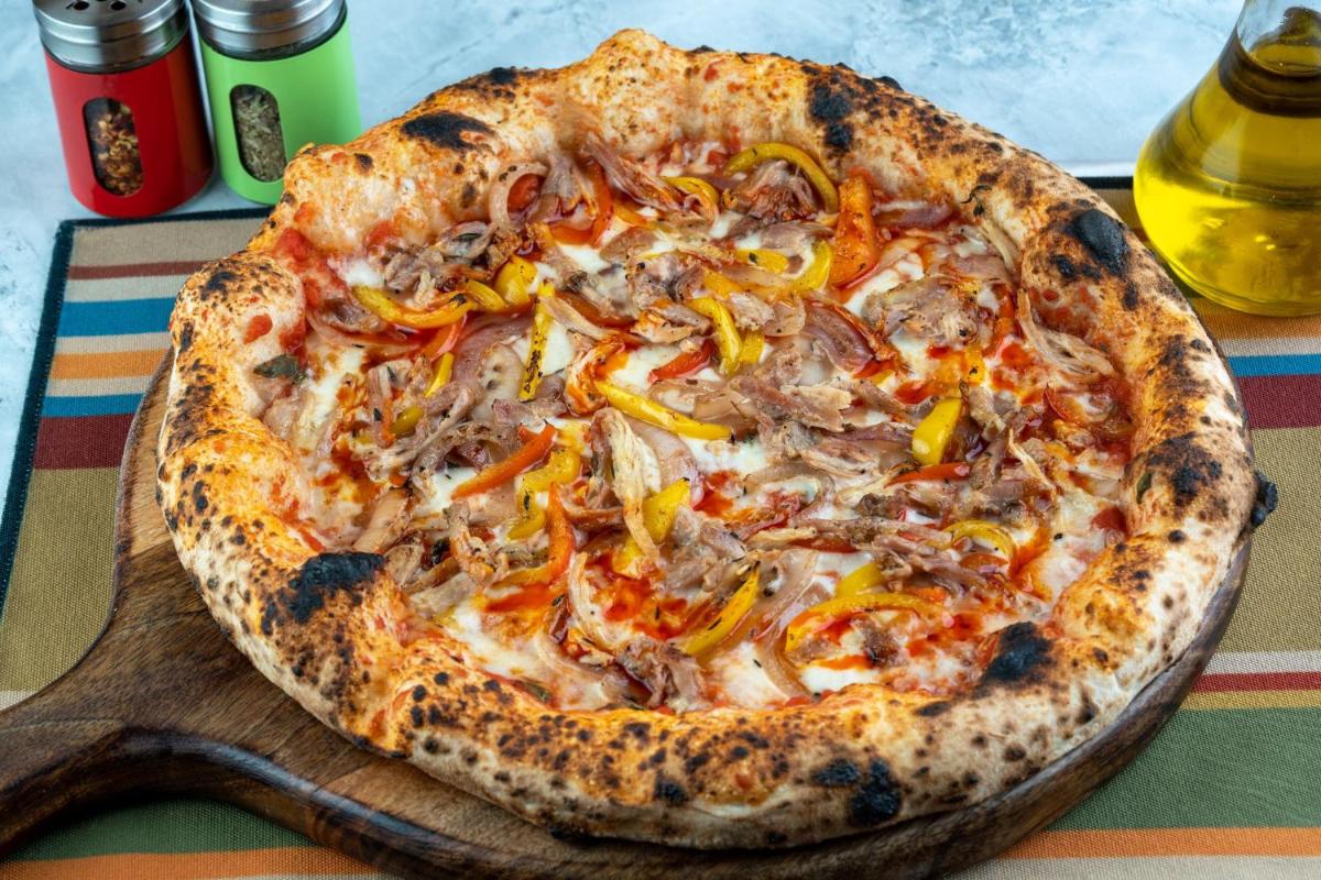 a pizza sitting on top of a wooden board at Holiday Inn New Delhi Aerocity by IHG in New Delhi