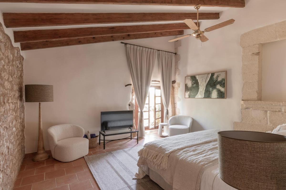 Un dormitorio con una cama y un ventilador de techo. en Reserva Rotana Golf Resort, en Manacor