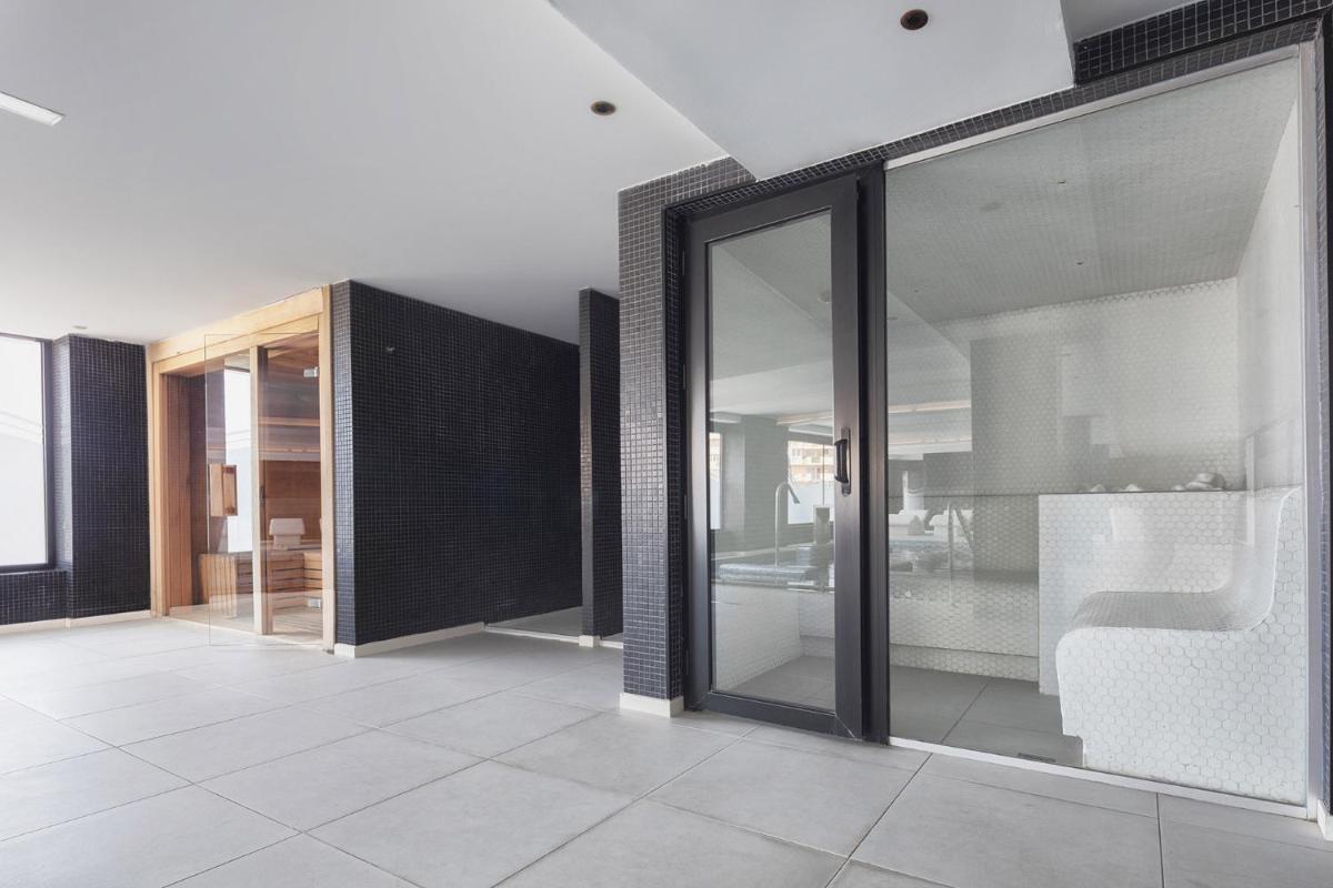sala de estar con puertas de cristal y suelo de baldosa. en Eurostars Puerto de Ibiza, en Ibiza