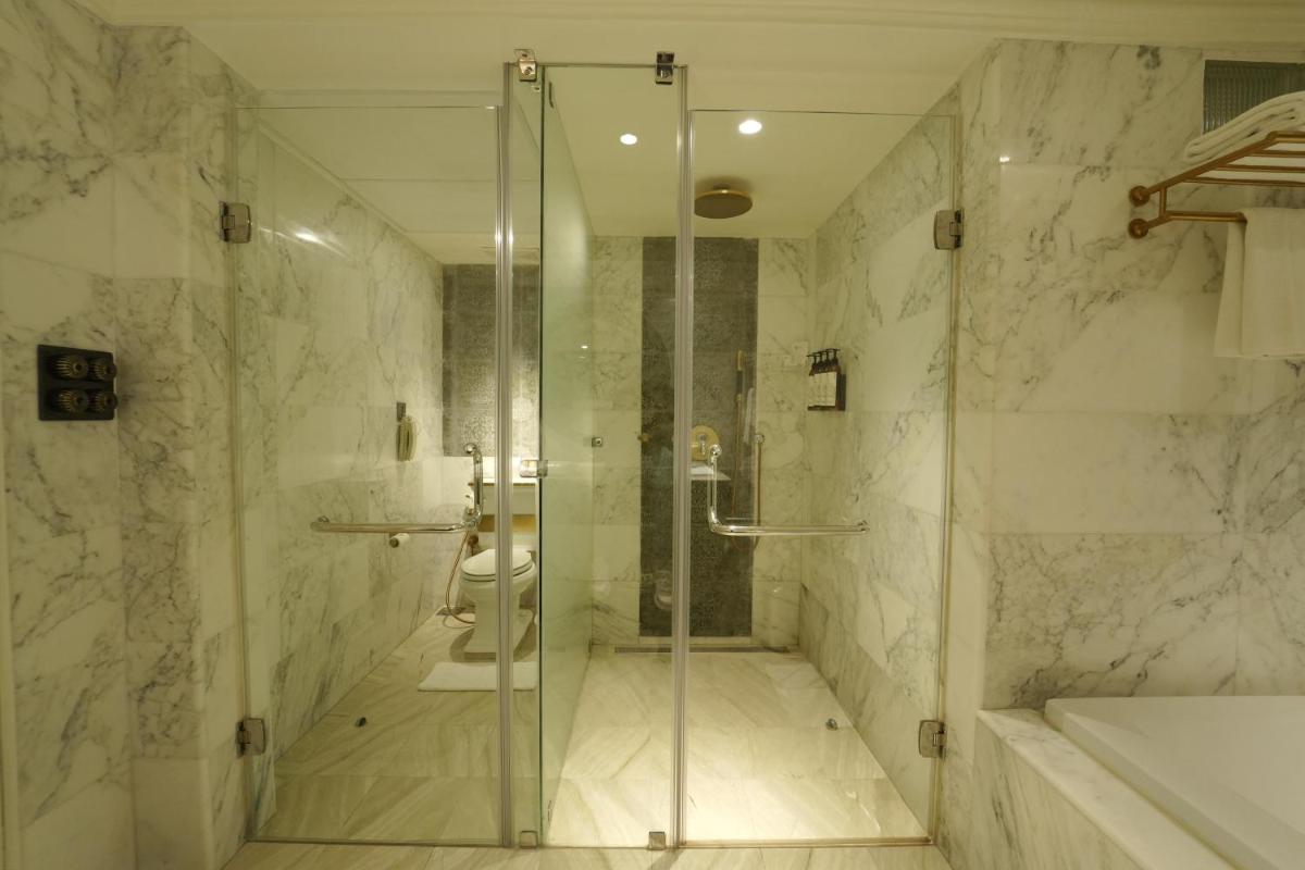 a bathroom with a glass shower and a toilet at Fragrant Nature Kochi - A Five star Classified Hotel in Cochin