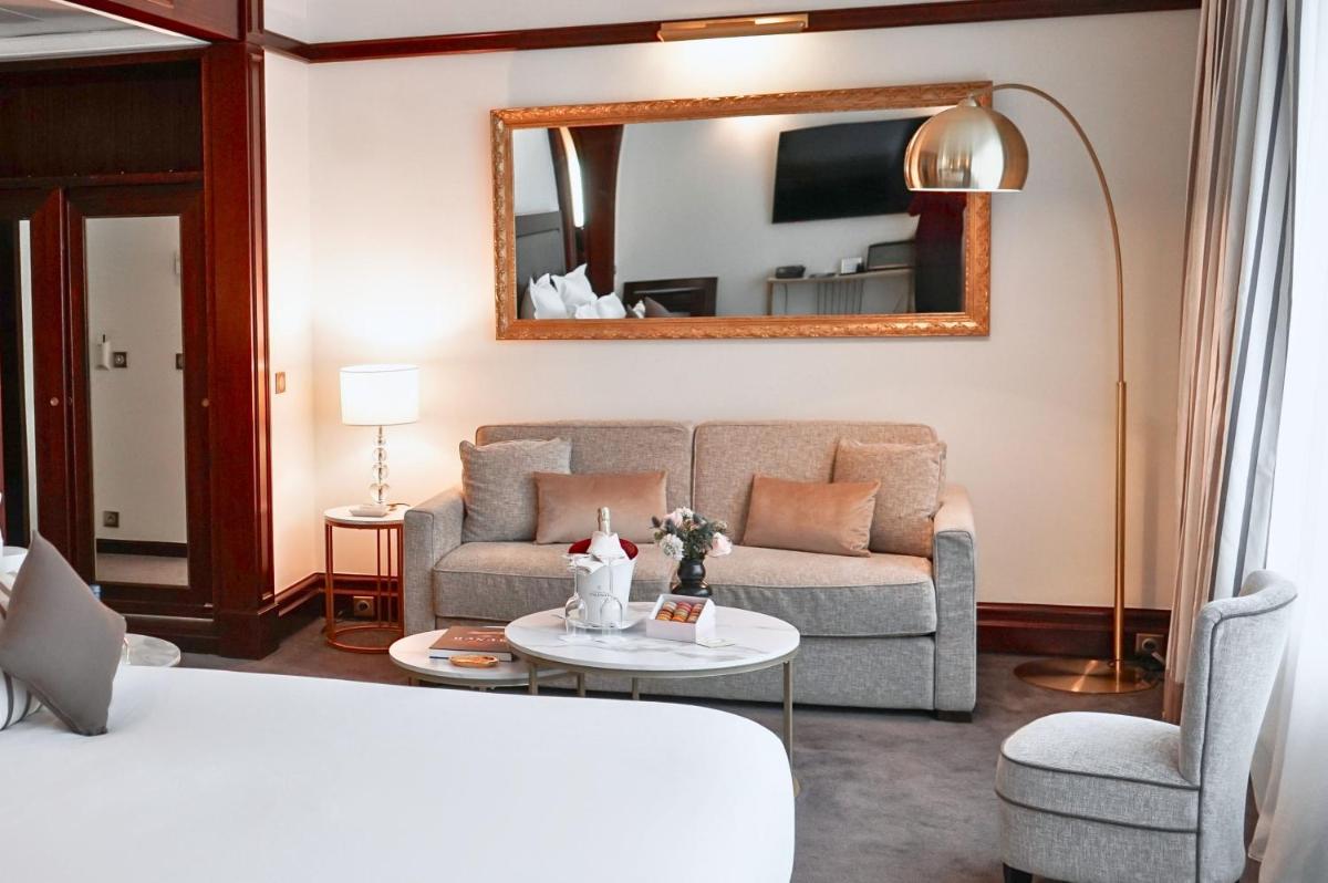 un salon avec un canapé et un miroir dans l'établissement Hôtel Pont Royal Paris, à Paris