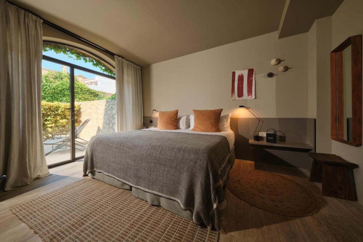 Un dormitorio con una cama y una ventana grande. en Can Aulí Luxury Retreat - Adults Only, en Pollensa