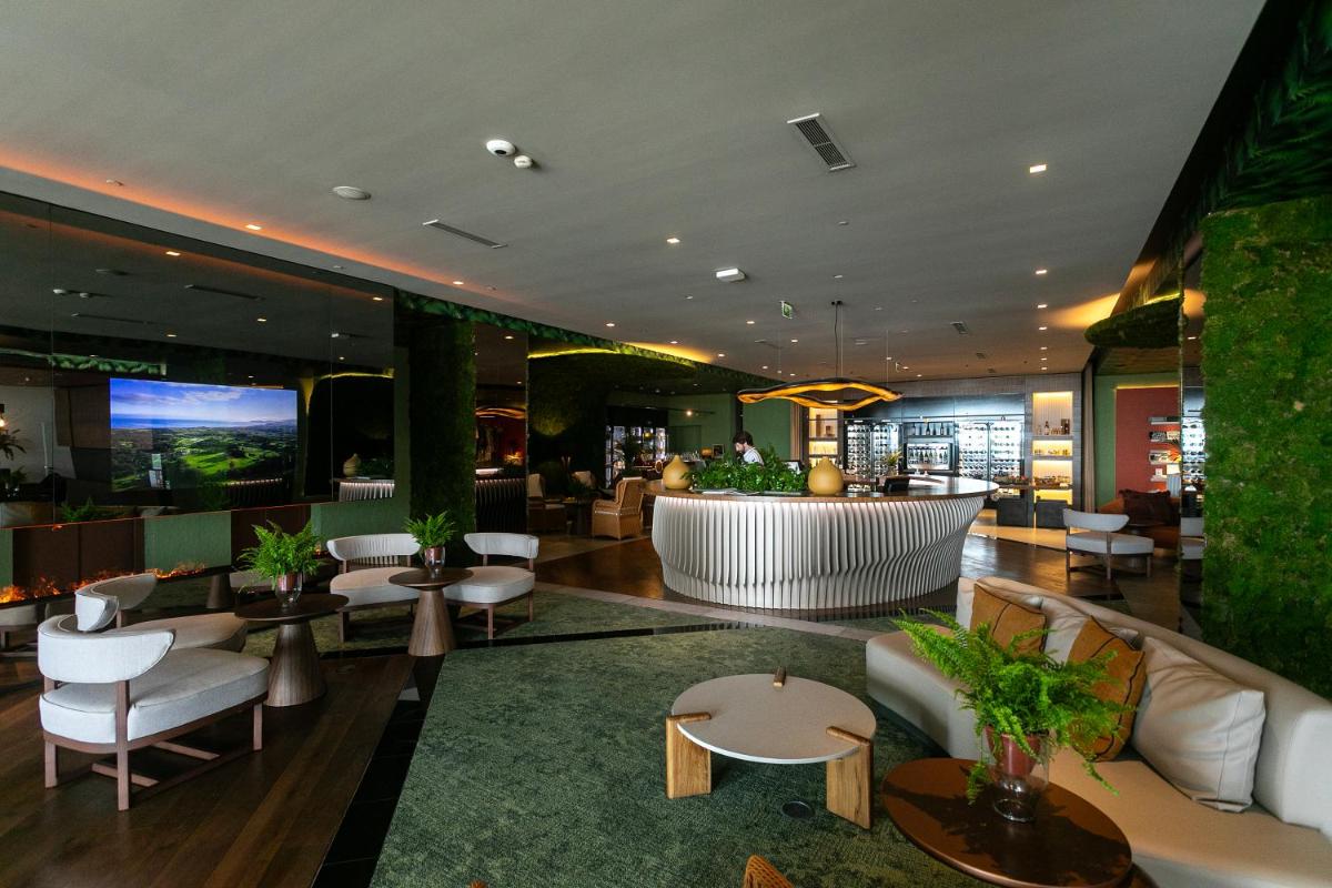 um átrio de um hotel com cadeiras e mesas brancas em Octant Ponta Delgada em Ponta Delgada