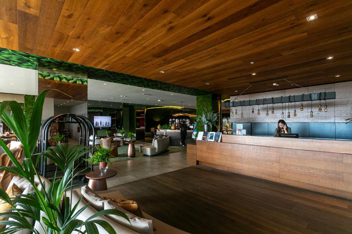 um lobby de um restaurante com uma mulher sentada num balcão em Octant Ponta Delgada em Ponta Delgada