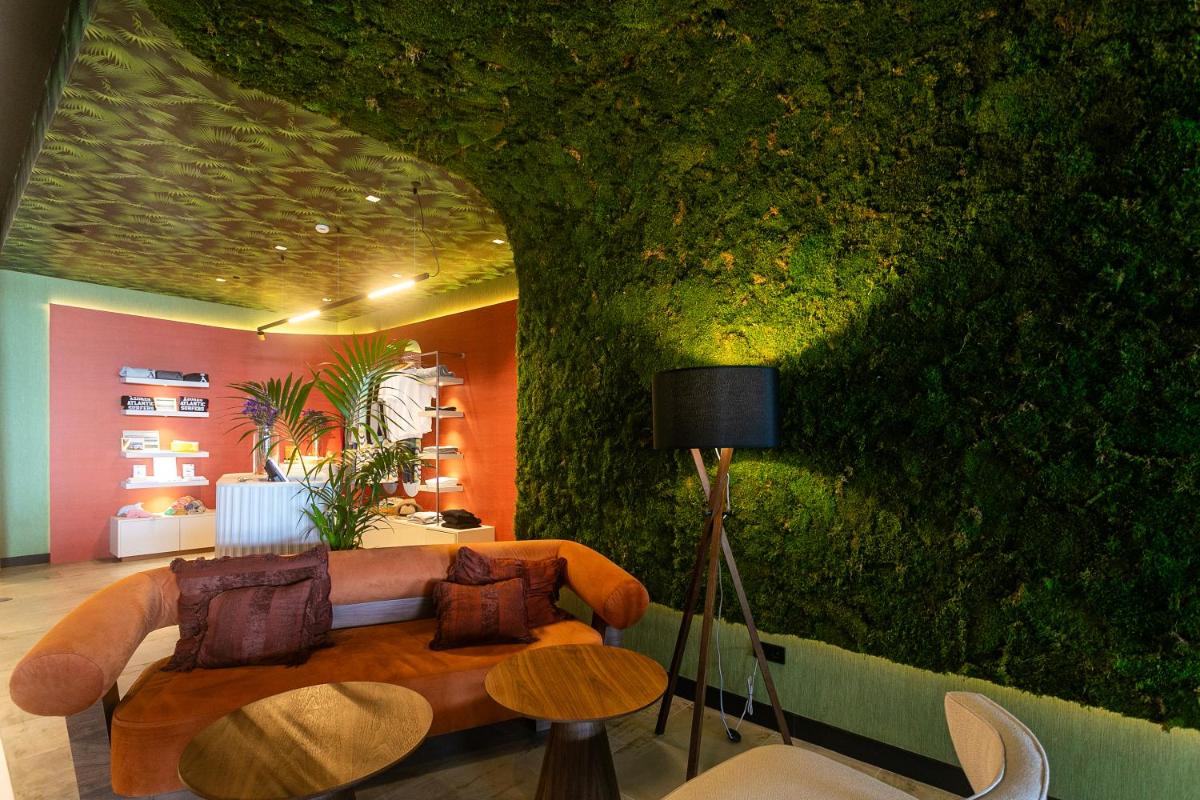 uma sala de estar com um sofá e uma parede verde em Octant Ponta Delgada em Ponta Delgada