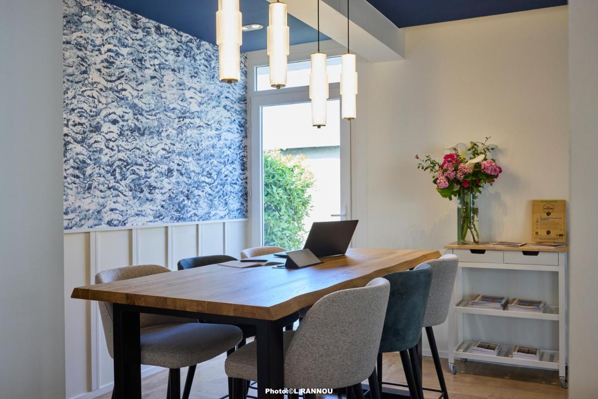 une salle à manger avec une table, des chaises et un ordinateur portable dans l'établissement The Originals Boutique, Hôtel La Marébaudière, Vannes, à Vannes