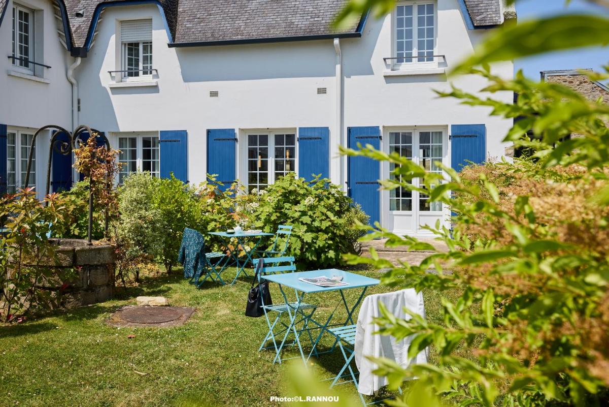 un jardin avec une table bleue devant une maison blanche dans l'établissement The Originals Boutique, Hôtel La Marébaudière, Vannes, à Vannes 89 autres photos