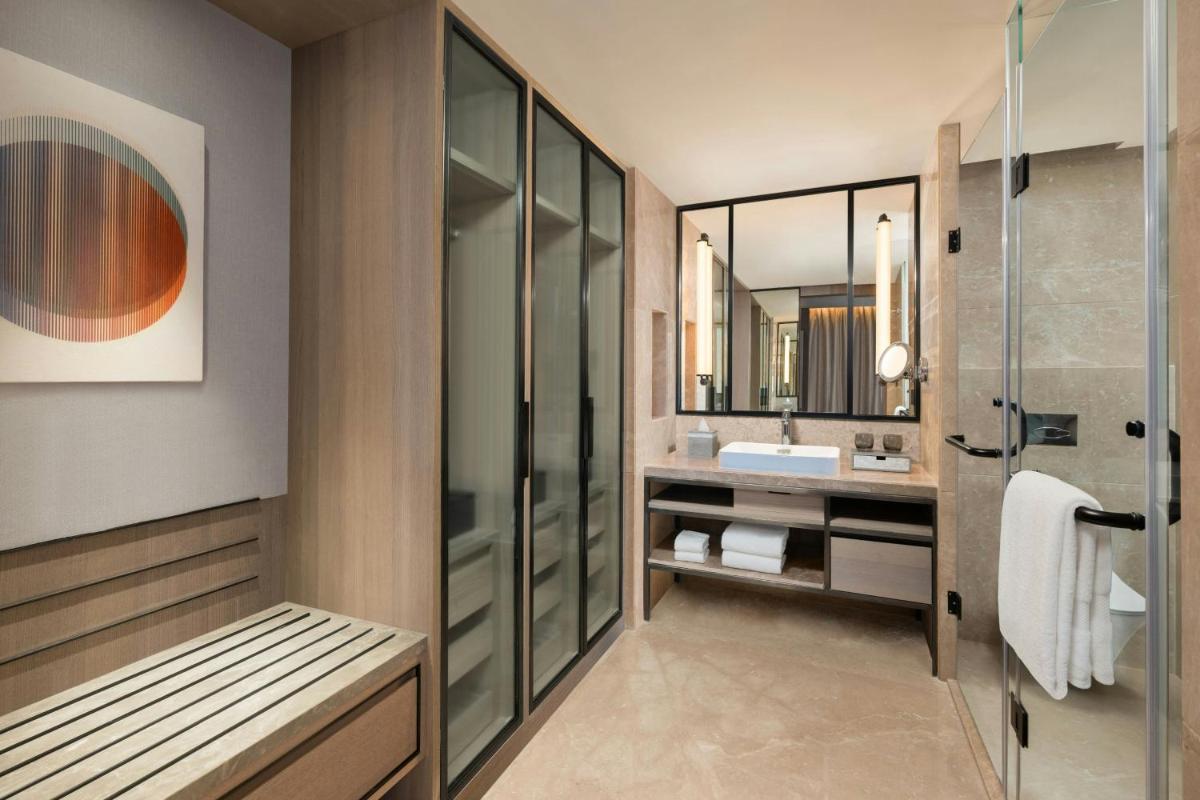 a bathroom with a shower and a sink at Le Meridien Ahmedabad in Ahmedabad
