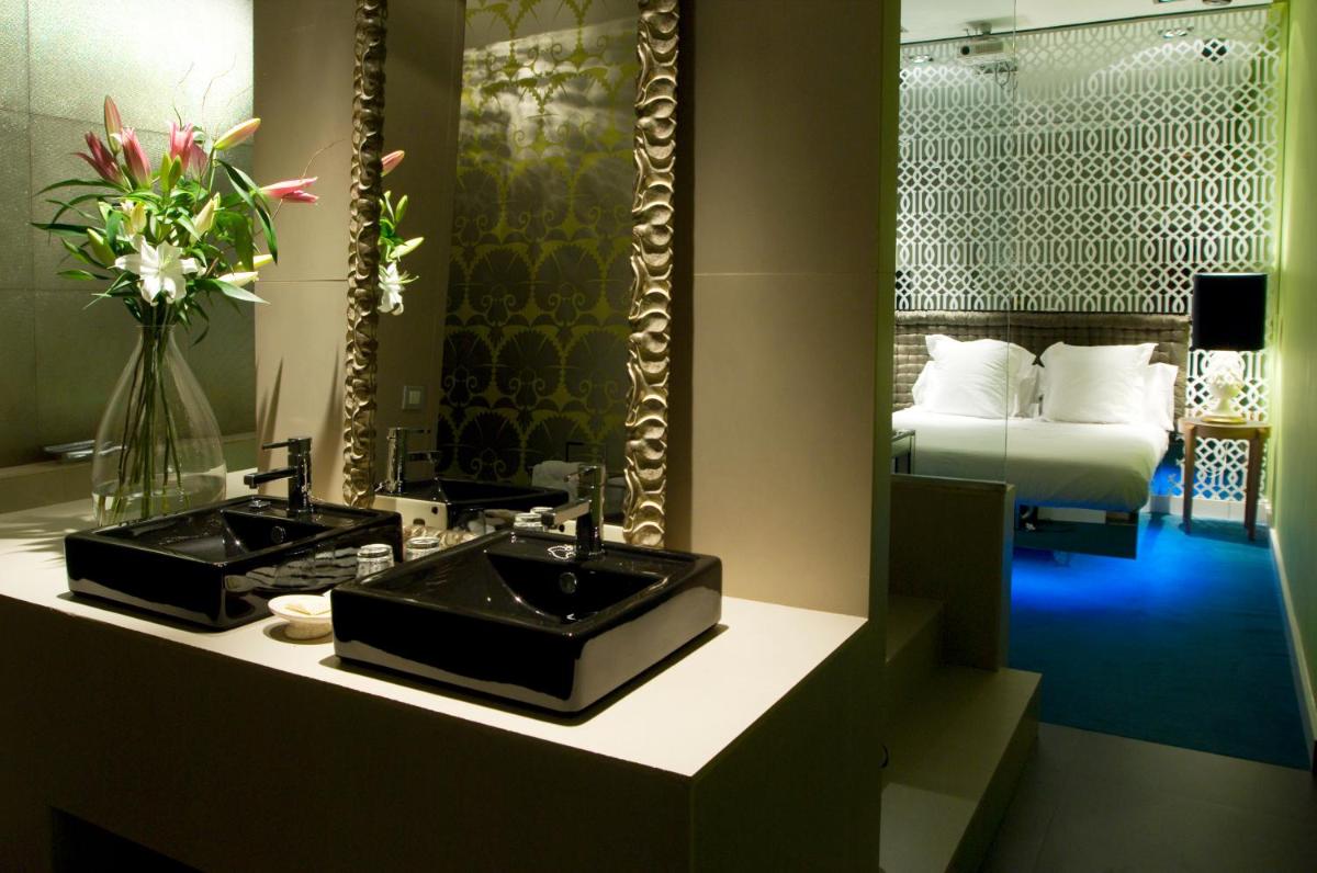 - Baño con 2 lavabos, espejo y cama en Abalú Design Boutique Hotel Gran Via, en Madrid