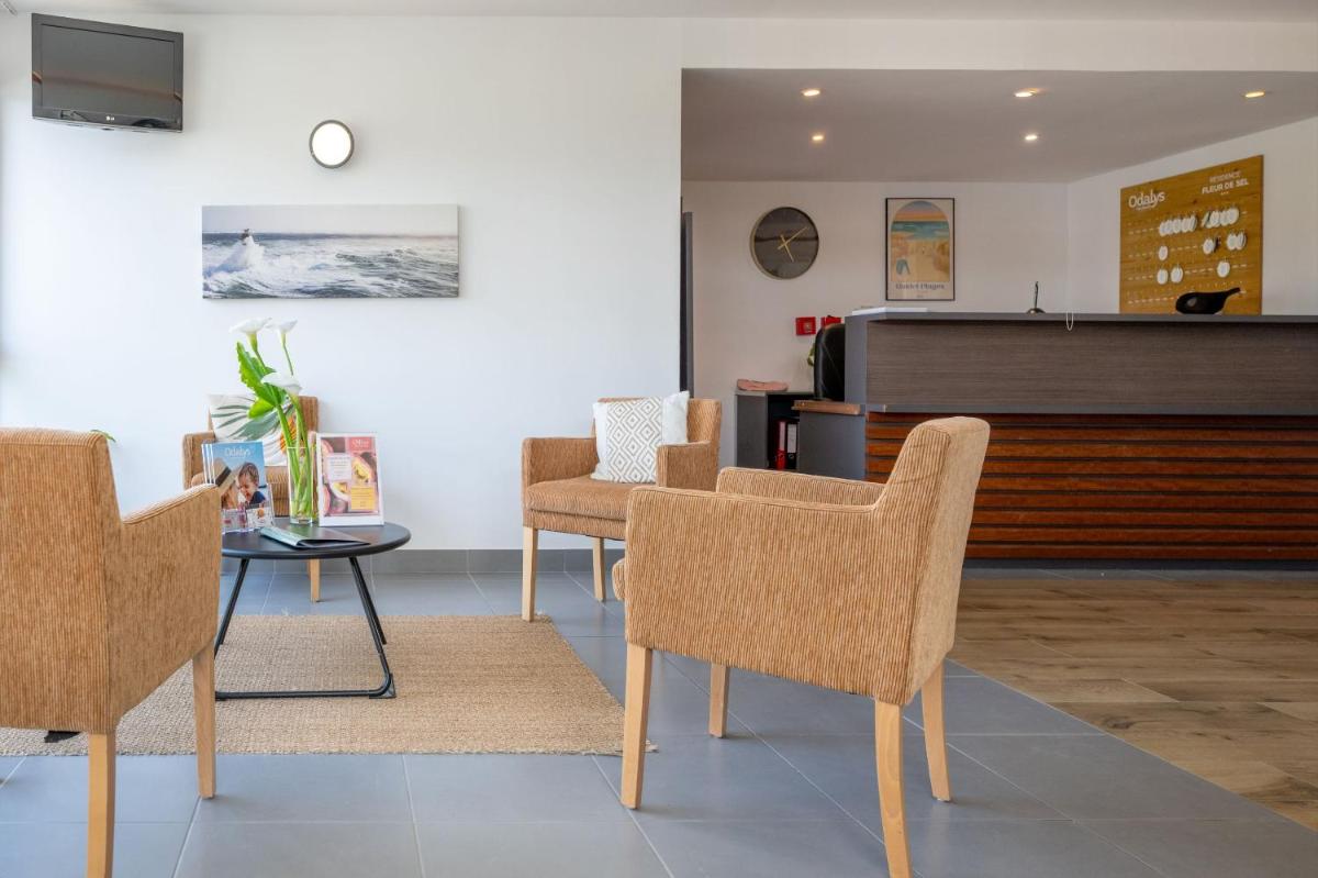 - une salle d'attente avec des chaises, une table et un piano dans l'établissement Résidence Odalys Fleur de Sel, à Guidel-Plage