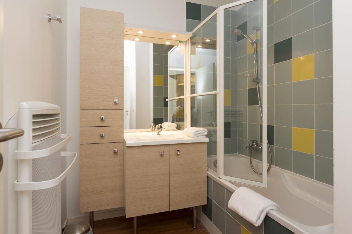 une salle de bain avec une douche, un lavabo et une baignoire dans l'établissement Résidence Odalys Fleur de Sel, à Guidel-Plage