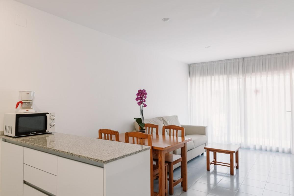 Una cocina y una sala de estar con mesa y sillas. en Hotel Lodomar Spa & Talasoterapia, en San Pedro del Pinatar