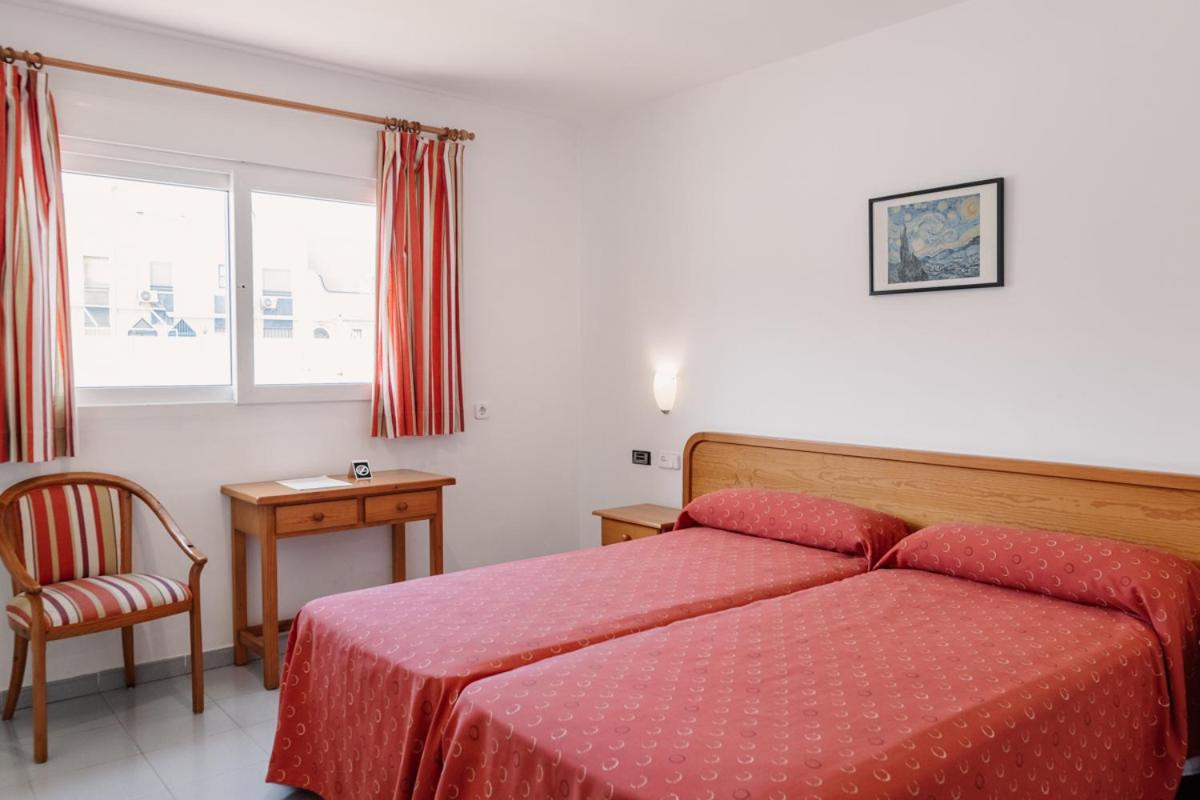 Un dormitorio con una cama roja con una silla y una ventana. en Hotel Lodomar Spa & Talasoterapia, en San Pedro del Pinatar 84 fotos más