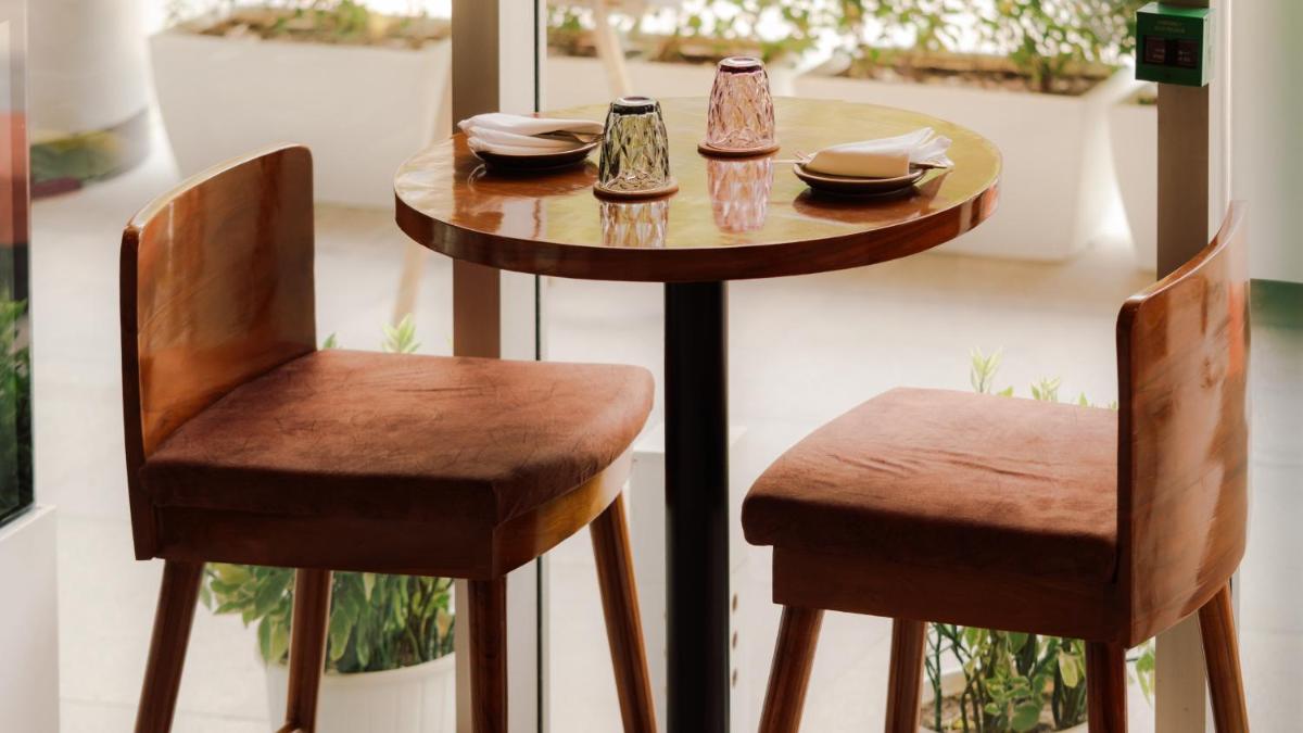 a small table with two chairs next to a window at Holiday Inn New Delhi Aerocity by IHG in New Delhi