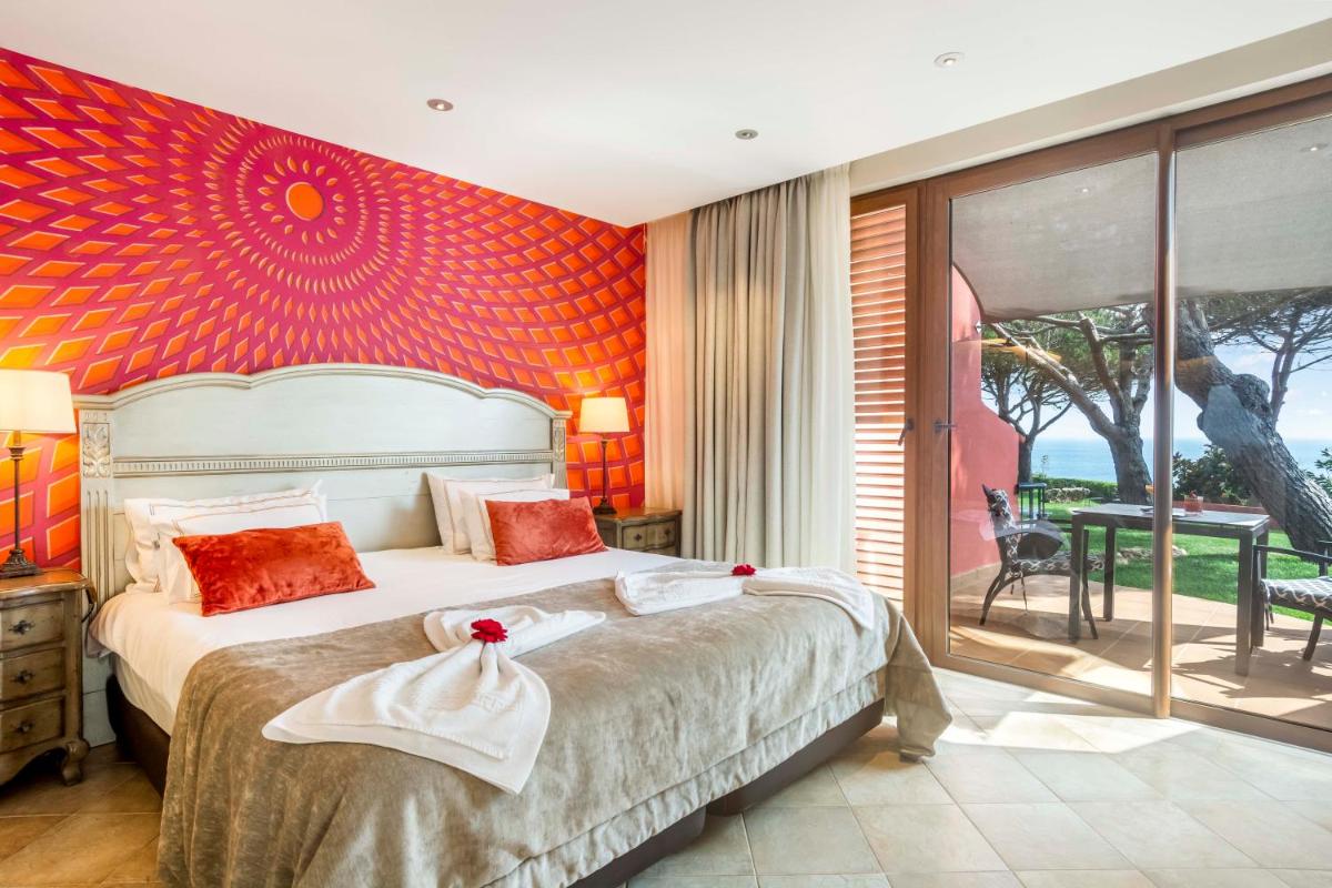 um quarto com uma cama grande com uma parede vermelha em Boutique Hotel Vivenda Miranda em Lagos