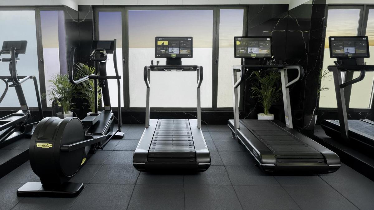a gym with treadmills and machines in a room at InterContinental Marine Drive Mumbai by IHG in Mumbai