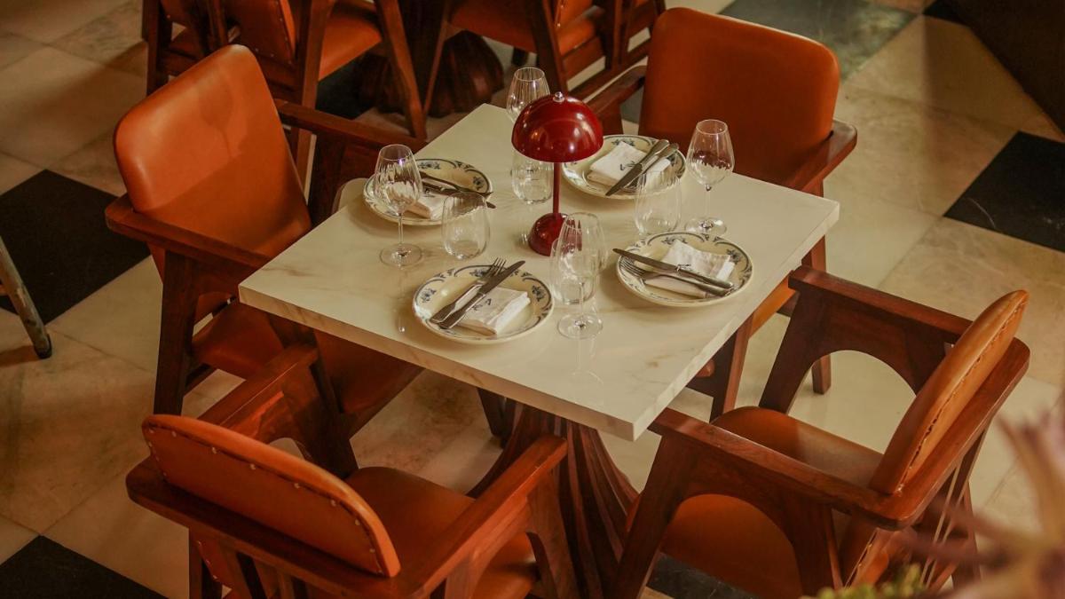 a table with plates and wine glasses on it at InterContinental Marine Drive Mumbai by IHG in Mumbai