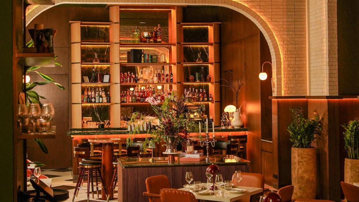 a restaurant with a bar with tables and chairs at InterContinental Marine Drive Mumbai by IHG in Mumbai